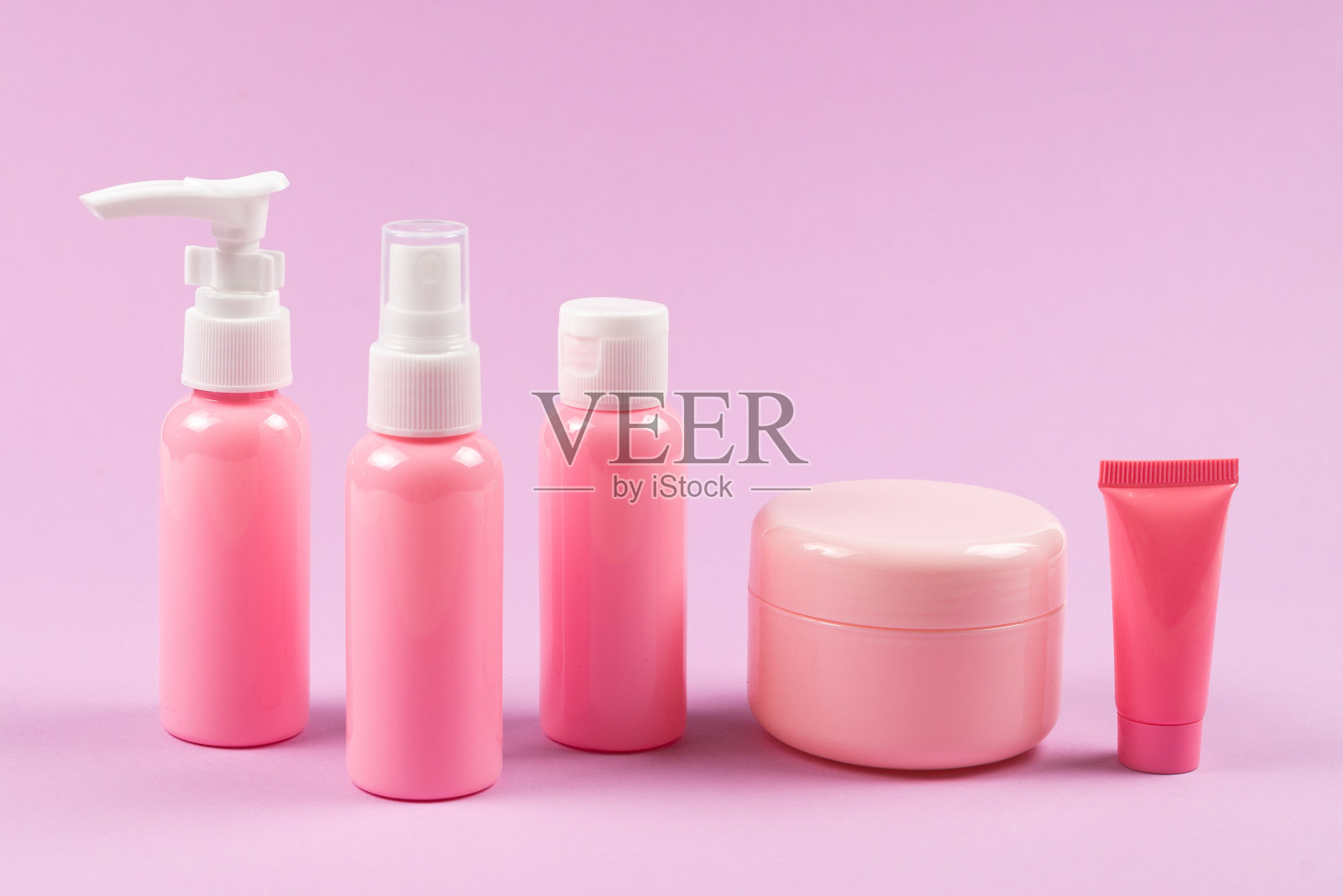 粉色塑料瓶用于卫生用品、化妆品、卫生用品上的粉色背景。照片摄影图片